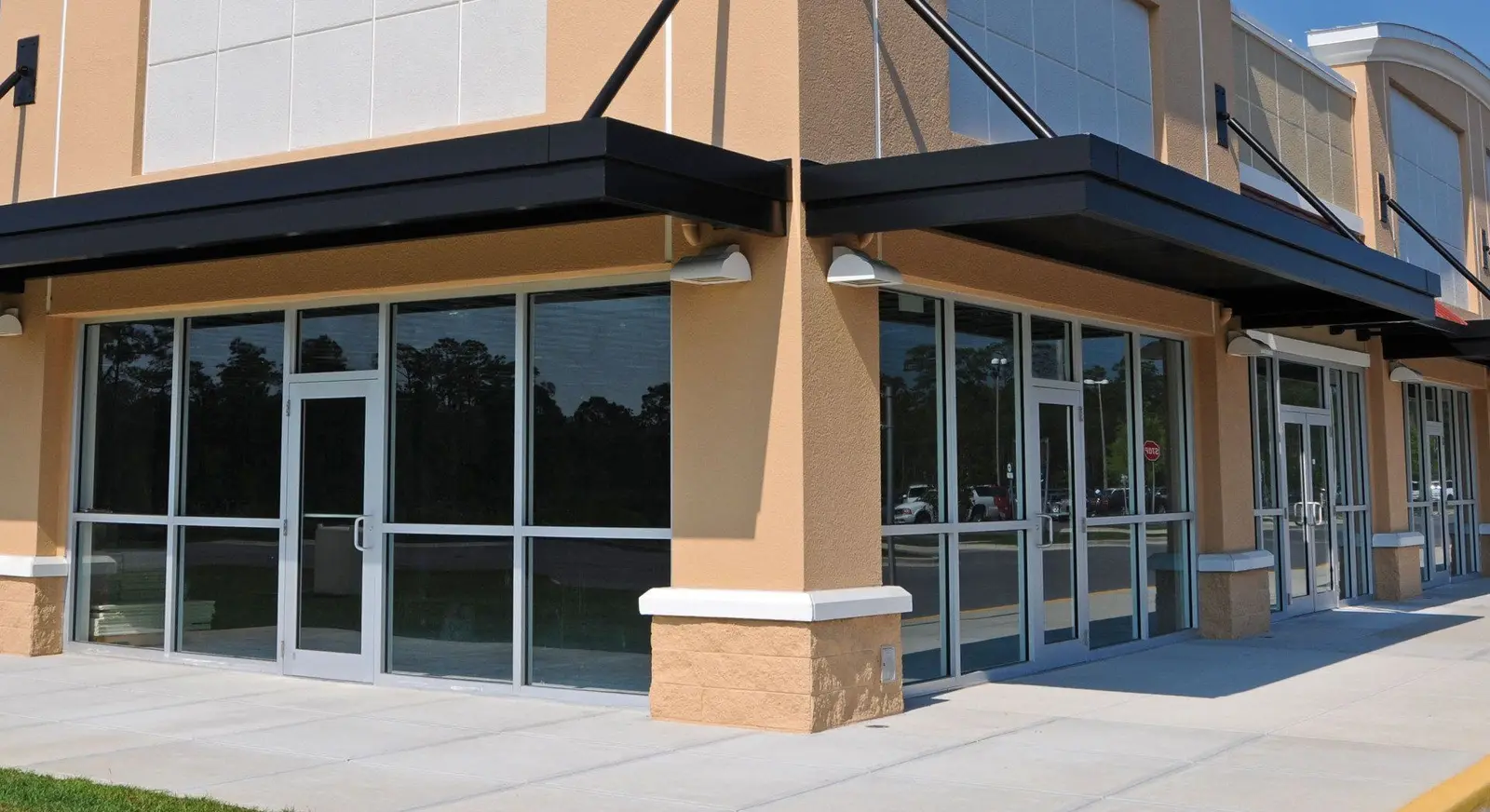 Completed retail storefront with glass entries along a new sidewalk
