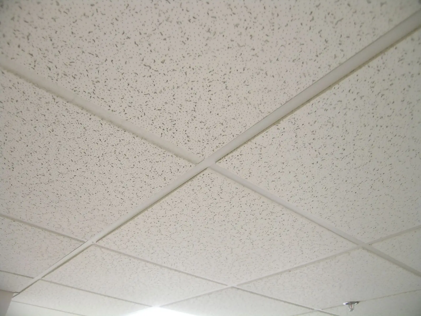 Close view of a suspended acoustical tile ceiling grid